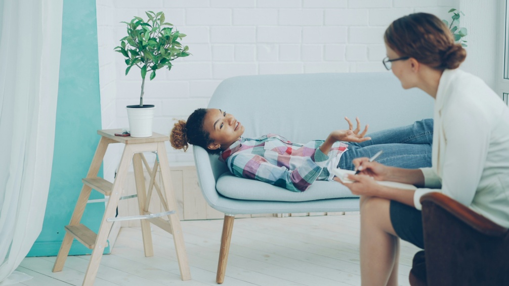 Individual reclining in a chair while speaking with a mental health provider in a calm, welcoming setting