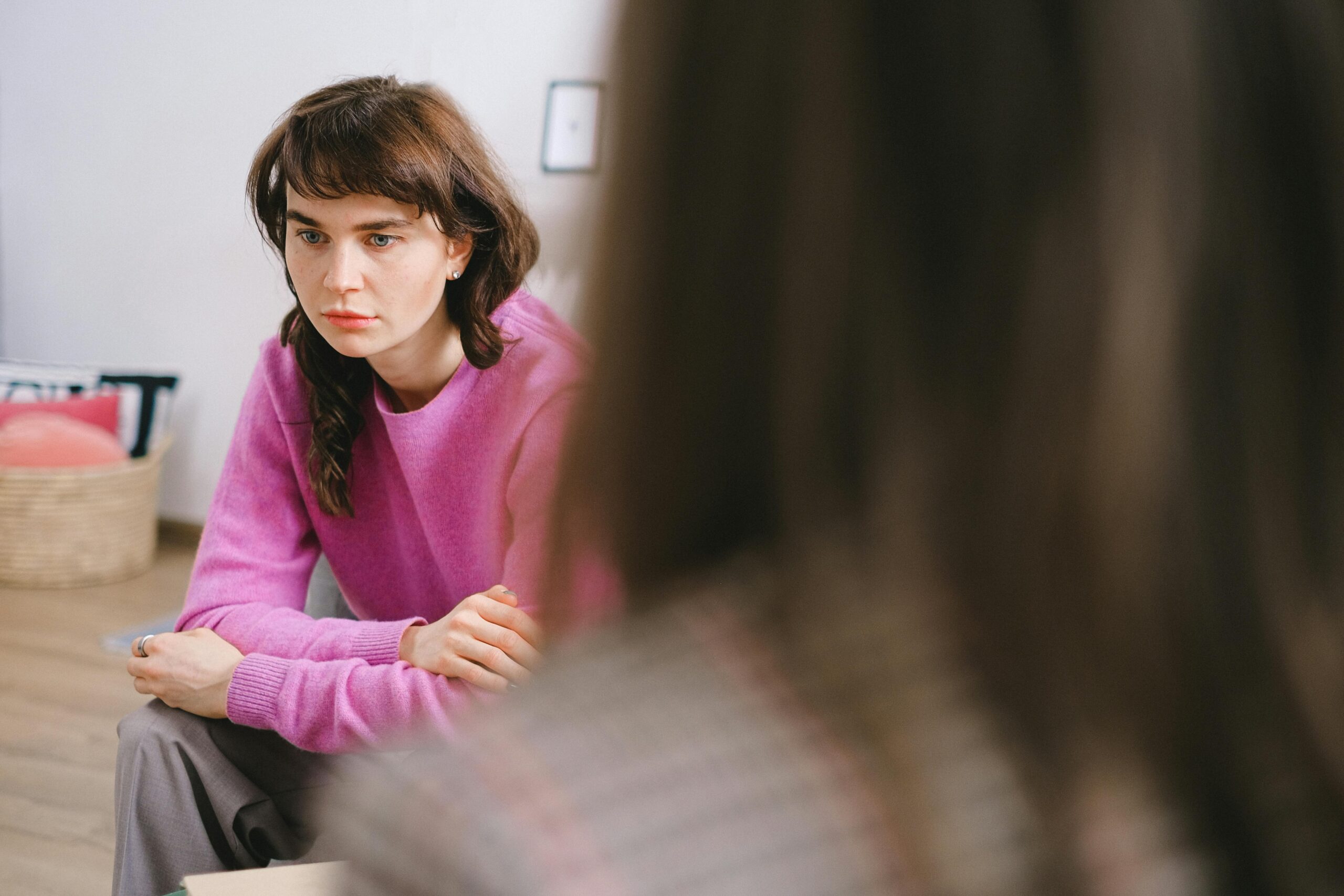 Woman sitting and listening attentively during a counseling or psychiatric appointment